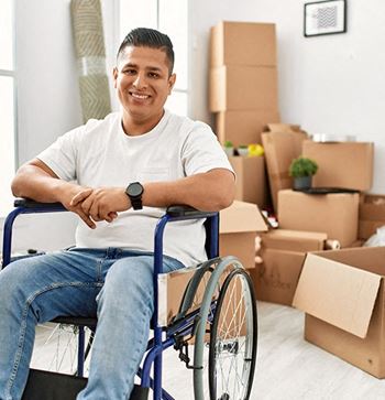 a man in a wheelchair in front of a pile of boxes